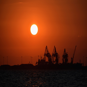 Image by papazachariasa titled ’sunset, port, cranes’. Source: Pixabay